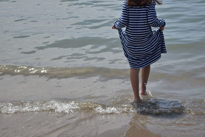 Rear view of woman standing on beach