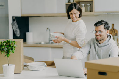 Smiling couple looking at laptop at new home