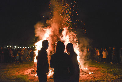 Rear view of people watching fire crackers at night