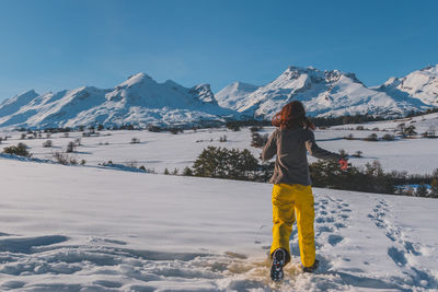 An unrecognizable young caucasian woman running towards the french alps mountains