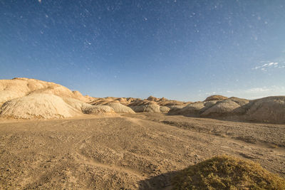 Scenic view of desert mountain forms like cake against dusty blue sky