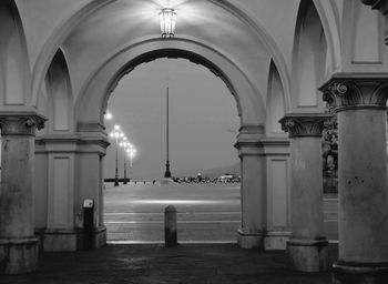 Illuminated town square seen from archway