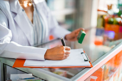 Midsection of doctor examining patient in clinic