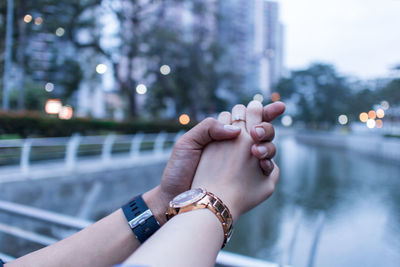 Midsection of woman hand on railing against water
