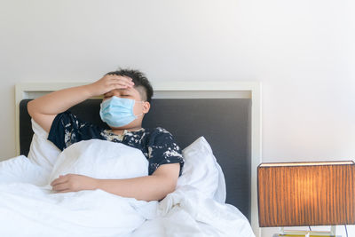 Boy sitting on bed at home