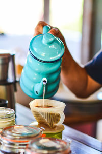 Cropped hand of man preparing coffee at home