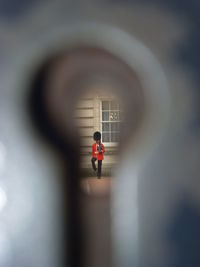 Rear view of person standing against wall