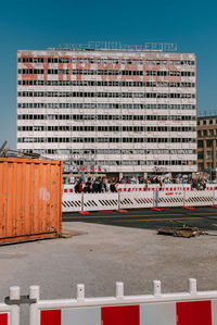 Road by buildings against sky in city