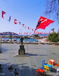 Flags on statue in city against sky