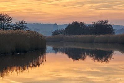 Scenic view of lake against orange sky