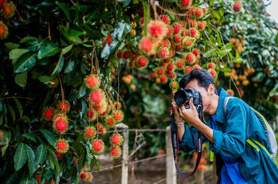 Man photographing with plants