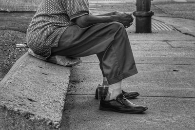 Low section of man sitting outdoors