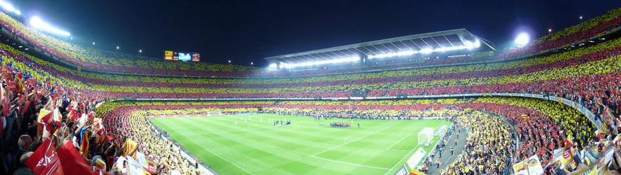 Crowd on soccer field against sky at night