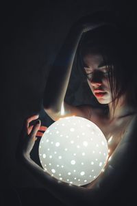 Woman holding illuminated lamp
