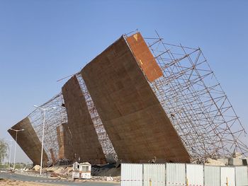 Low angle view of abandoned building against clear blue sky