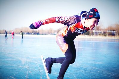 Full length of woman snowboarding against sky