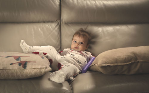 Full length of cute baby lying on bed at home