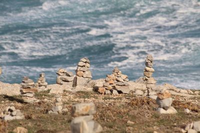 Stone wall by sea against cloudy sky