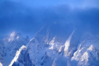 Scenic view of snowcapped mountains against blue sky