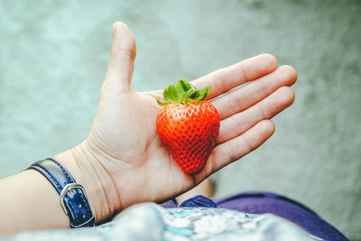 Close-up of hand holding strawberry