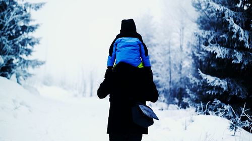 Rear view of man standing in snow