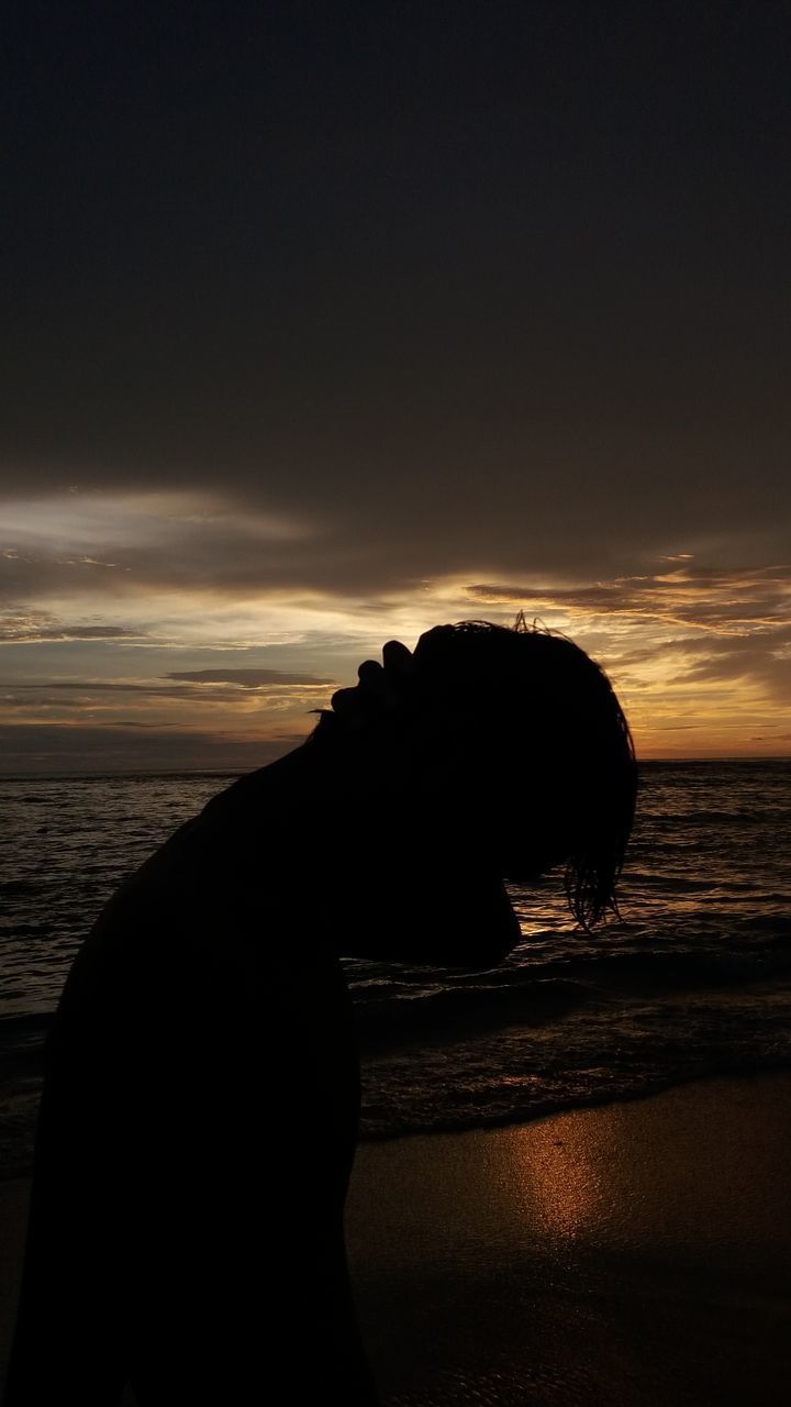 SILHOUETTE ROCK ON BEACH AGAINST SKY AT SUNSET