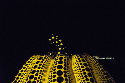 Low angle view of illuminated ferris wheel against sky at night