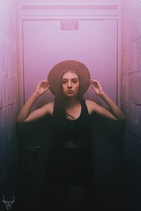 Woman standing against wall at home