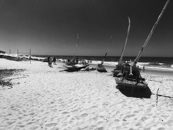 Fishing boats on beach against sky