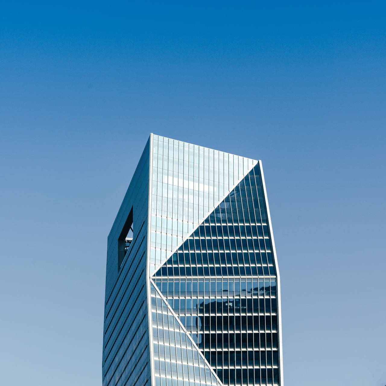 LOW ANGLE VIEW OF MODERN BUILDING AGAINST BLUE SKY