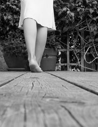 Low section of woman standing on footpath