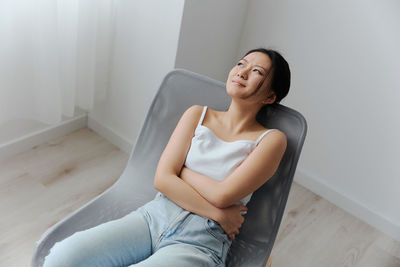 Woman having constipation sitting at home