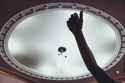 Low angle view of human hand against sky