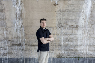 Portrait of mature man standing by wall