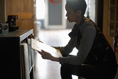 Side view of young woman reading book