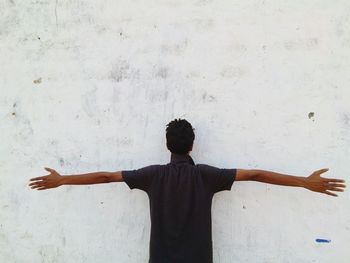 Rear view of man standing against wall