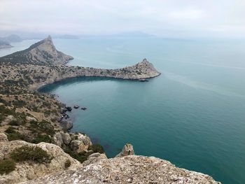 High angle view of sea by cliff against sky