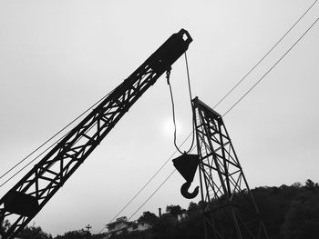 Low angle view of crane against sky