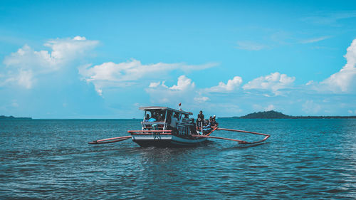 Fishing boat sailing in sea against sky