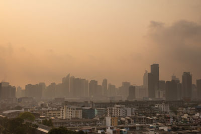 Aerial view of buildings in city against sky during sunset