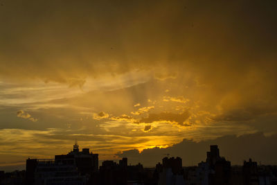 Silhouette buildings against sky during sunset