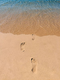 High angle view of footprints on sand at beach