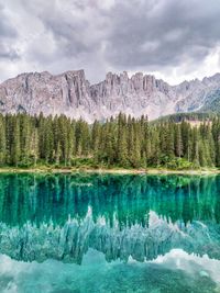 Scenic view of lake by mountains against sky