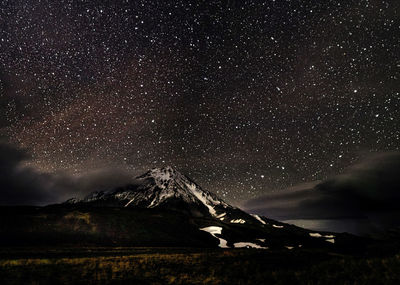 Scenic view of snowcapped mountains against sky at night