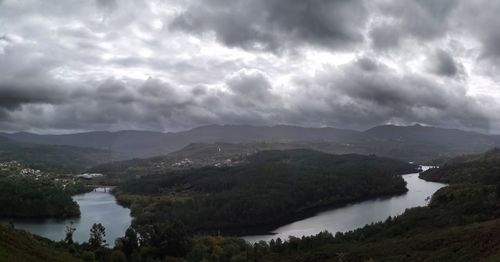 Scenic view of river and mountains against sky