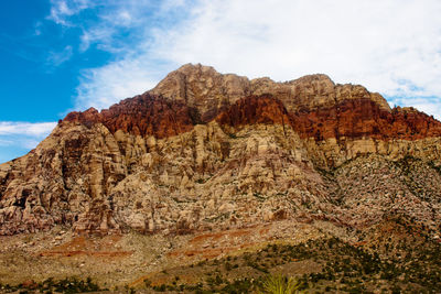 Rock formations on mountain against cloudy sky