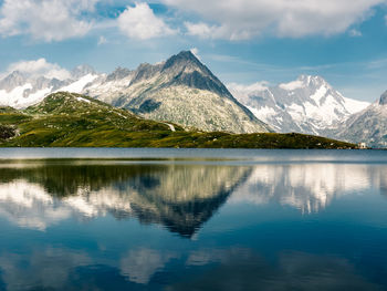 Scenic view of lake by mountains against sky