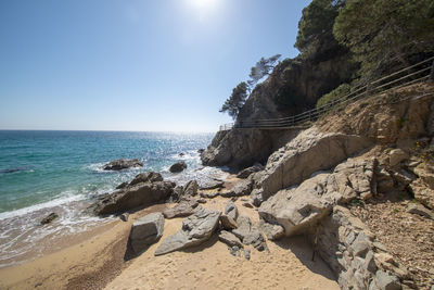 Scenic view of rocks on beach against sky