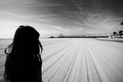 Rear view of woman standing against sky