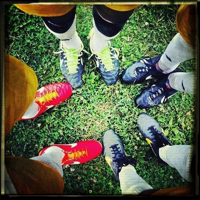 low section, person, shoe, human foot, lifestyles, men, footwear, standing, personal perspective, leisure activity, jeans, togetherness, high angle view, field, canvas shoe, grass